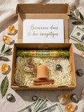 Box abondance ouverte avec encens HEM Patchouli, spell jar abondance cannelle et herbes, bougie pilier pêche cannelée, sphère pyrite, bâtons de cannelle sur frisure kraft
