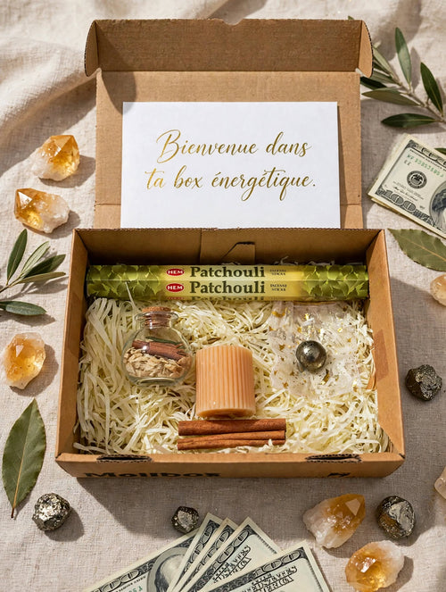Box abondance ouverte avec encens HEM Patchouli, spell jar abondance cannelle et herbes, bougie pilier pêche cannelée, sphère pyrite, bâtons de cannelle sur frisure kraft
