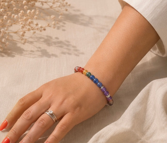 
Bracelet 7 chakras Porté composé de perles naturelles multicolores, posé sur un tissu en lin beige avec des fleurs séchées.