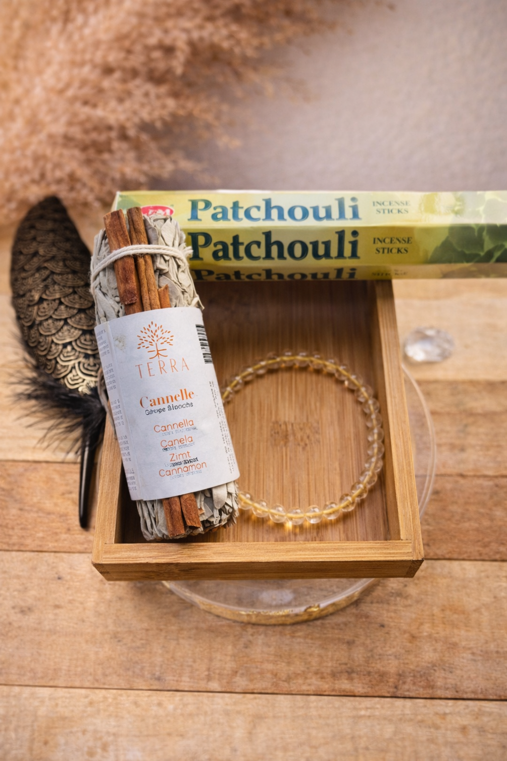 Coffret purification avec sauge blanche et cannelle, bracelet en pierre naturelle et encens patchouli présenté dans une boîte en bois.