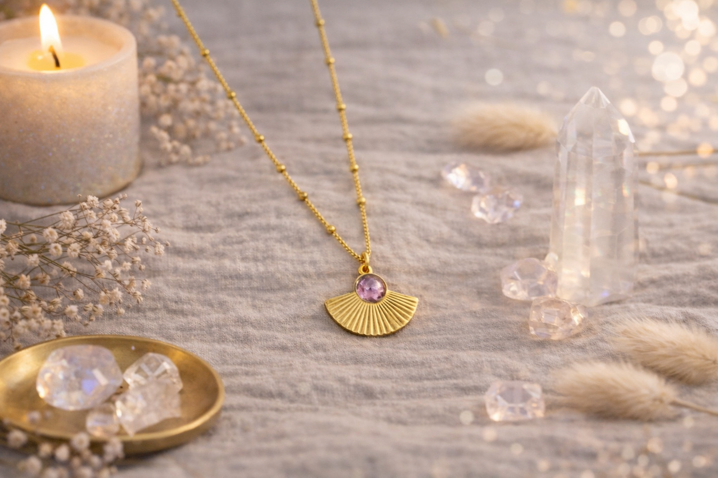Collier doré avec pendentif éventail et pierre violette porté autour du cou d’une femme, bijou élégant et lumineux.
