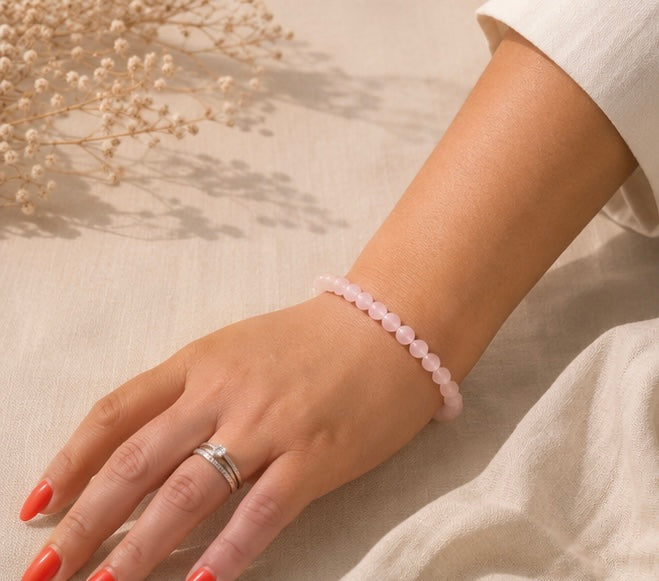 Bracelet Quartz, rose naturel porté sur un fond en lin beige, entouré de quelques fleurs séchées dans une ambiance douce et lumineuse.